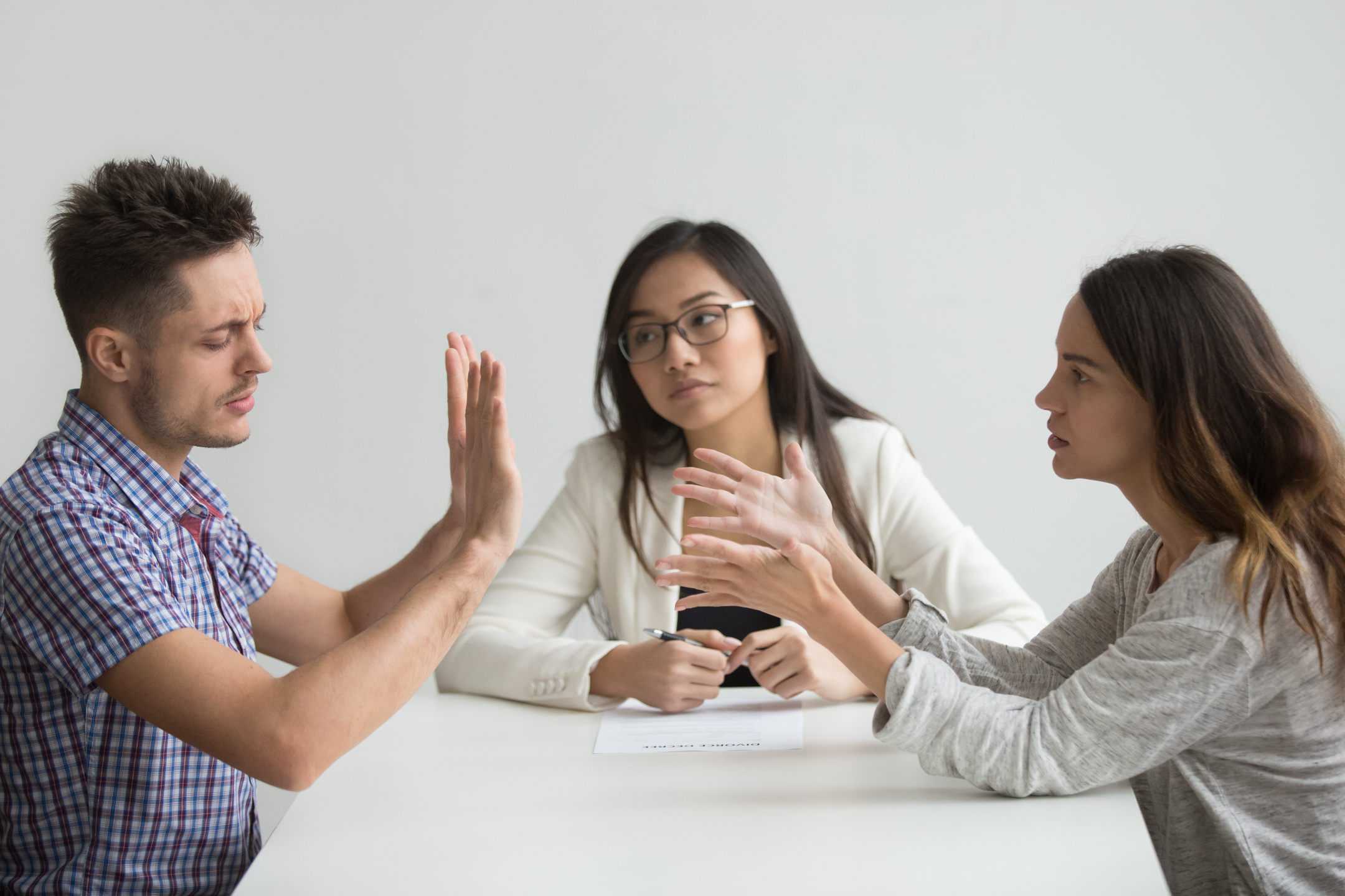 Unhappy married couple getting divorced arguing fighting in lawyers office