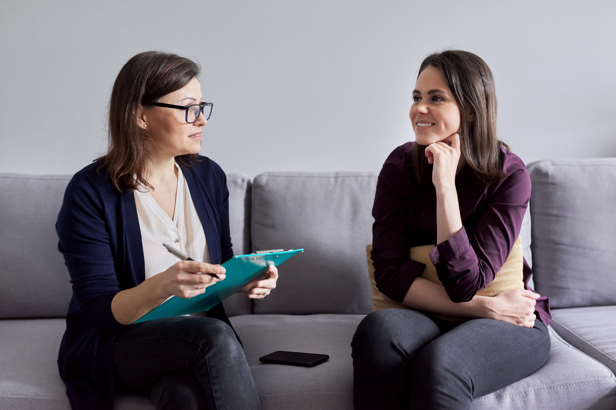 Social worker, psychologist talking to young woman in office.